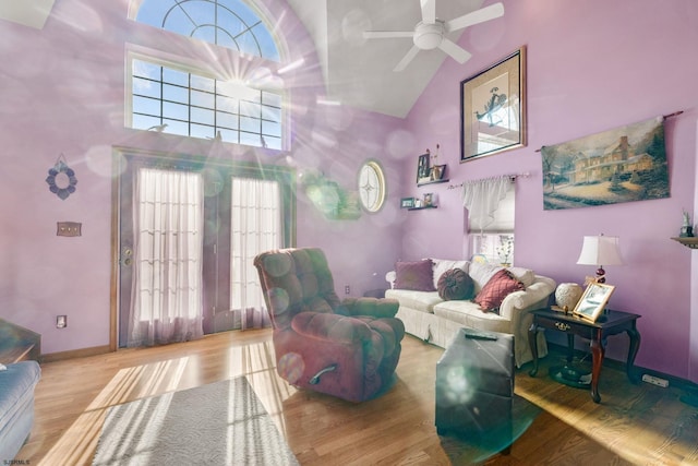 living room with high vaulted ceiling, a wealth of natural light, wood-type flooring, and ceiling fan