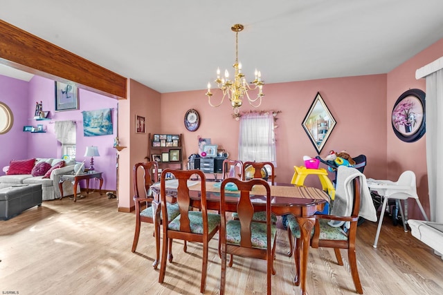 dining space with hardwood / wood-style flooring and a chandelier