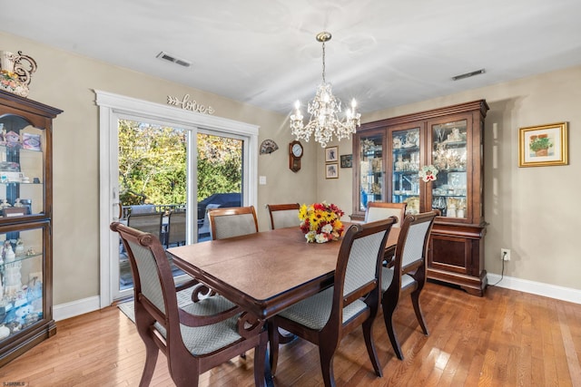 dining area featuring light hardwood / wood-style floors and an inviting chandelier