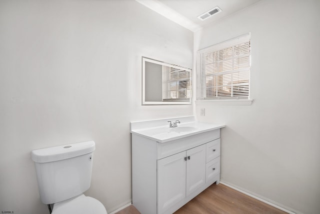 bathroom with hardwood / wood-style floors, vanity, and toilet