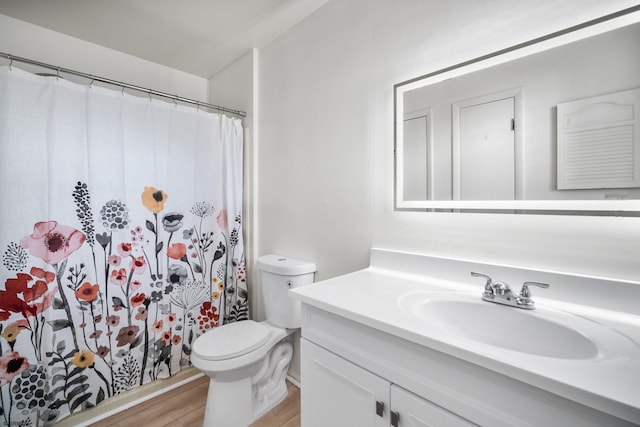 bathroom featuring a shower with curtain, vanity, wood-type flooring, and toilet