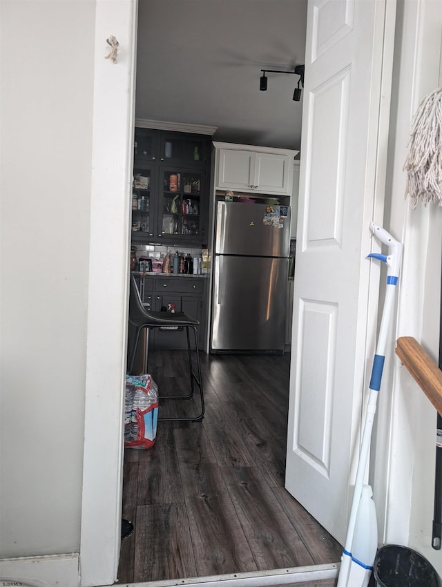 kitchen with white cabinets, dark wood-type flooring, and stainless steel fridge