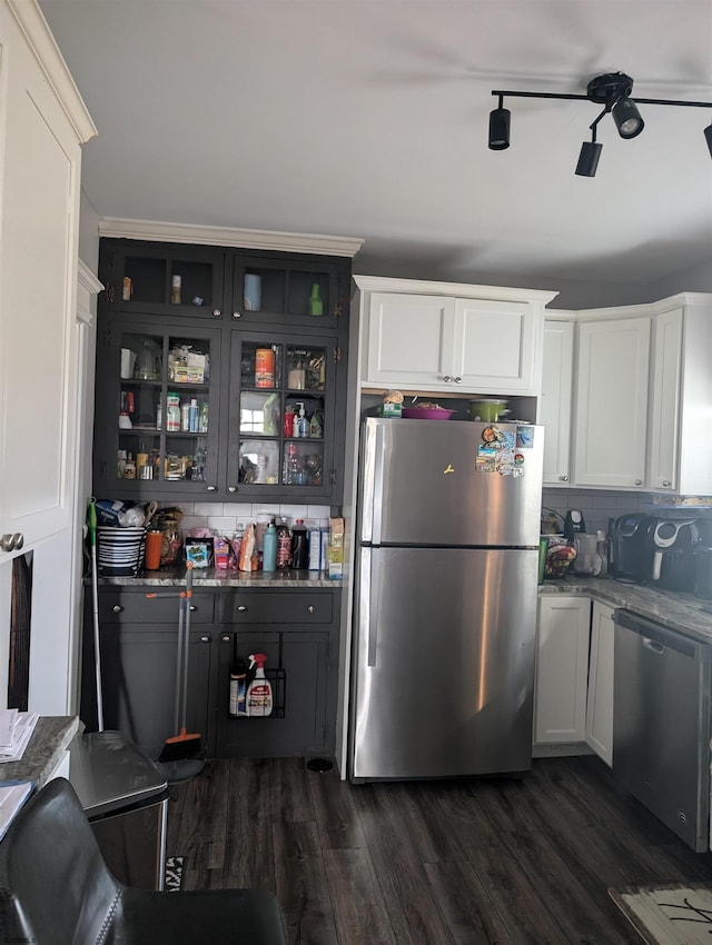 kitchen with decorative backsplash, white cabinetry, dark hardwood / wood-style floors, and stainless steel appliances