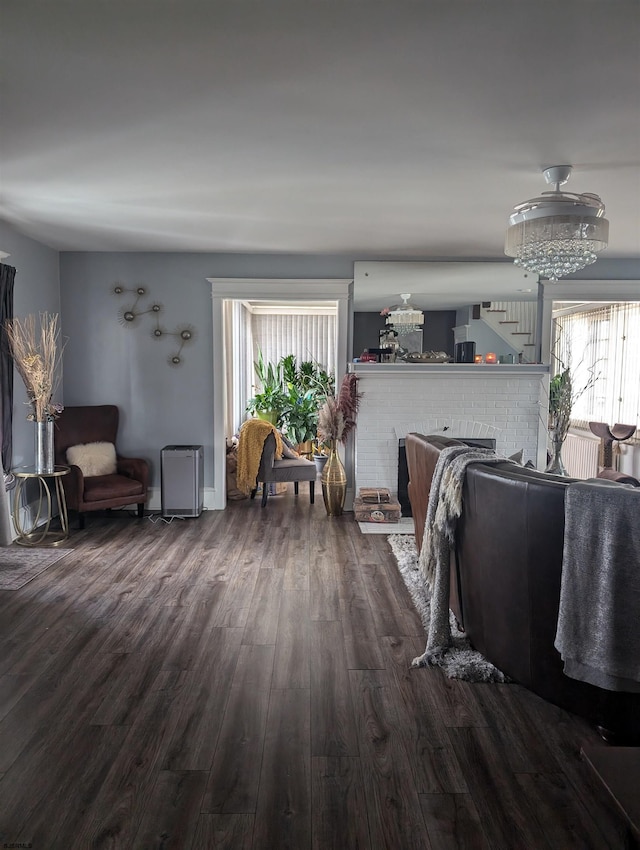 living room with a fireplace and dark wood-type flooring