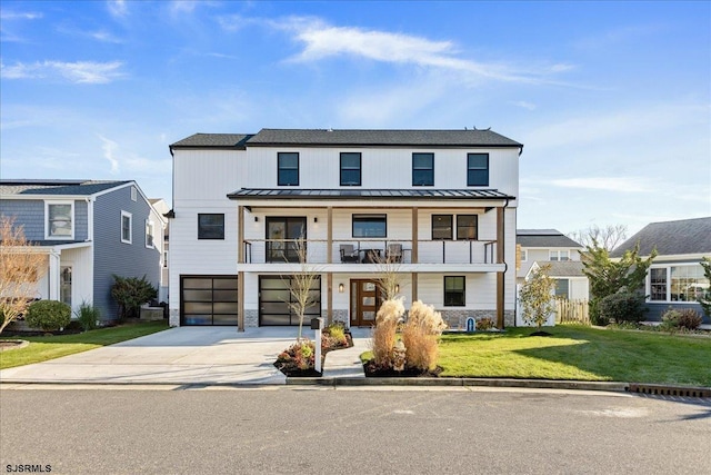 view of front facade with a front yard, a garage, and a balcony