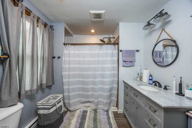 bathroom with hardwood / wood-style floors, a baseboard heating unit, vanity, curtained shower, and toilet