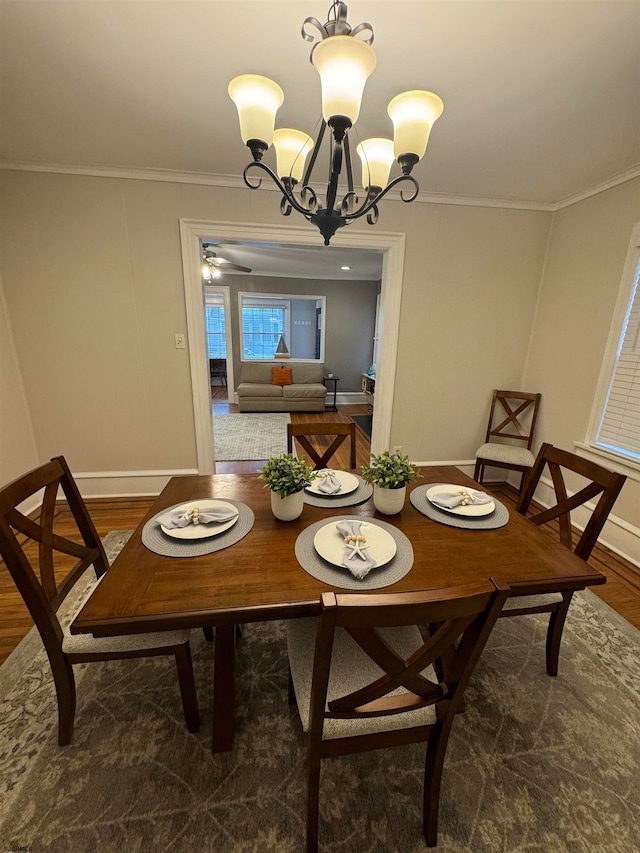 dining area with dark hardwood / wood-style floors, ornamental molding, and a chandelier