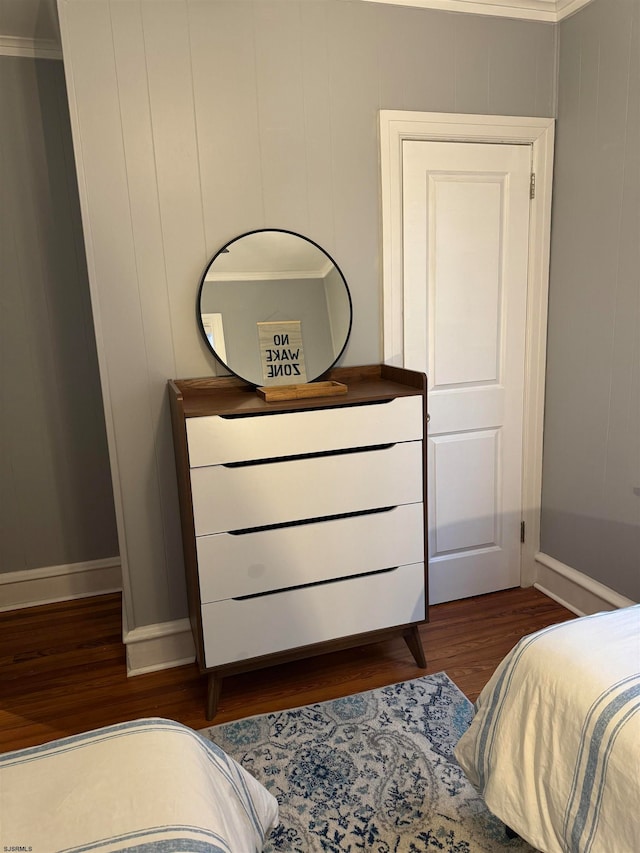 bedroom with dark hardwood / wood-style floors and ornamental molding