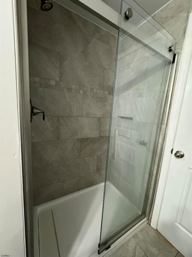 bathroom featuring combined bath / shower with glass door