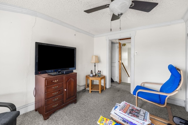 living area with a textured ceiling, light colored carpet, ceiling fan, and ornamental molding