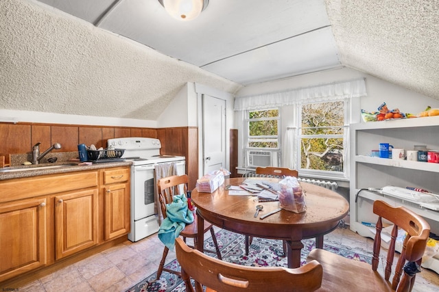 dining space featuring wood walls, cooling unit, sink, vaulted ceiling, and a textured ceiling