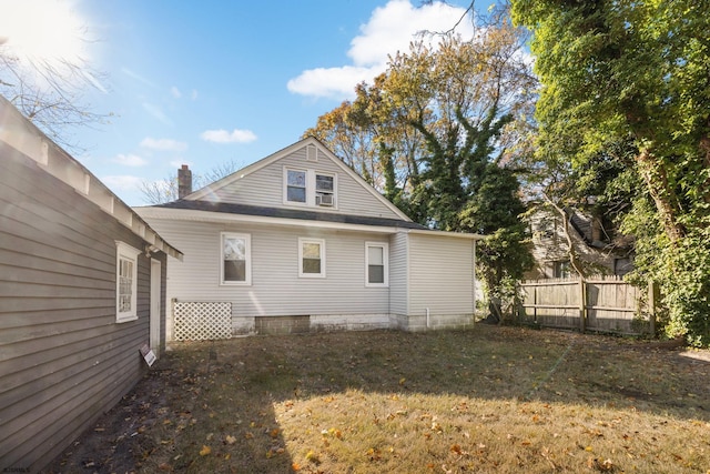 rear view of property featuring a lawn