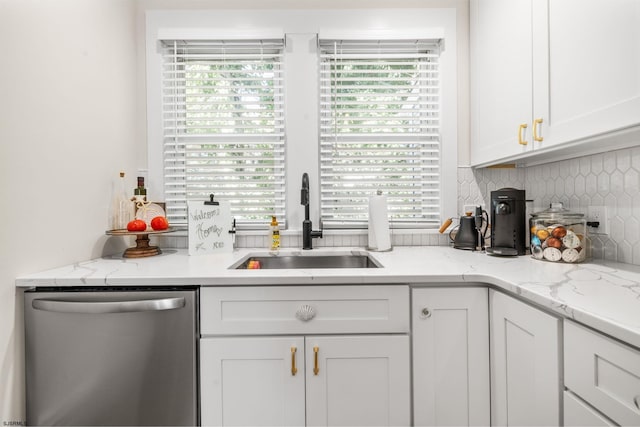 kitchen with sink, stainless steel dishwasher, tasteful backsplash, light stone counters, and white cabinetry