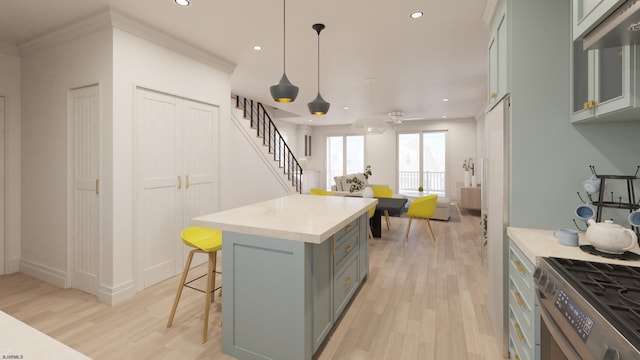 kitchen with a breakfast bar area, recessed lighting, light countertops, light wood-style floors, and gas range