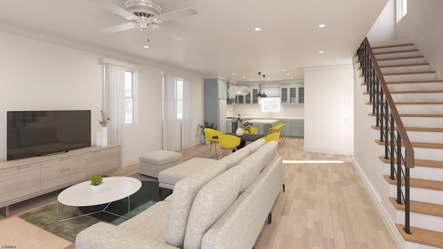 living area featuring light wood finished floors, ornamental molding, stairway, and baseboards