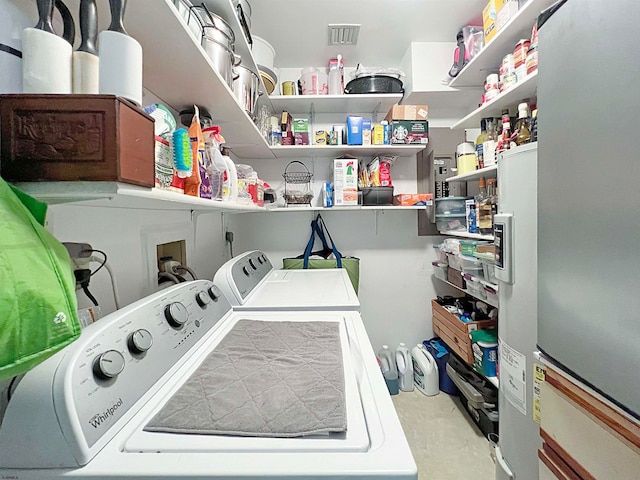 clothes washing area with separate washer and dryer and water heater