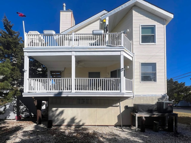 rear view of house with central AC, ceiling fan, and a balcony