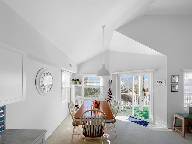 dining room featuring light carpet and vaulted ceiling