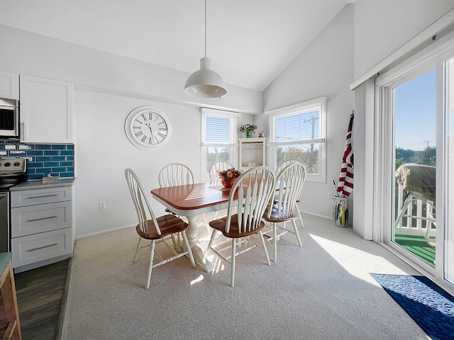 carpeted dining space featuring lofted ceiling