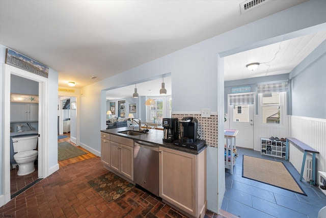 kitchen featuring light brown cabinetry, tasteful backsplash, stainless steel dishwasher, sink, and pendant lighting