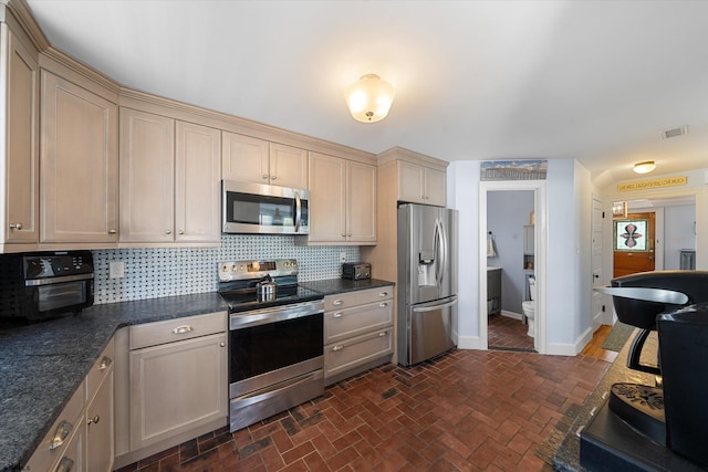 kitchen with tasteful backsplash and appliances with stainless steel finishes