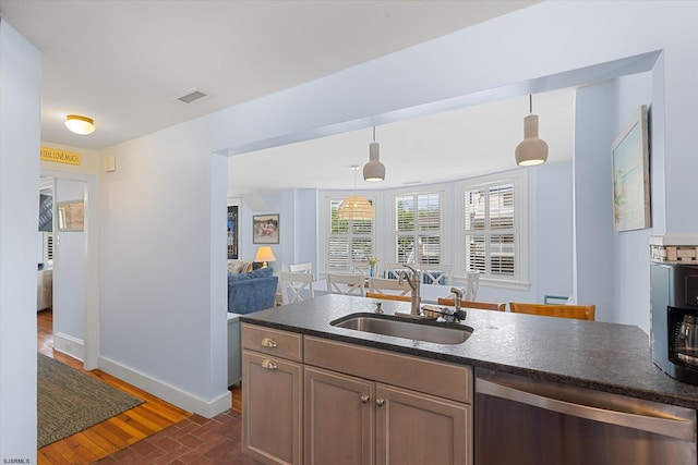 kitchen featuring dishwasher, dark hardwood / wood-style flooring, hanging light fixtures, and sink