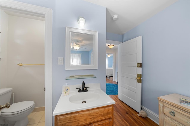 bathroom with tile patterned flooring, vanity, toilet, and ceiling fan