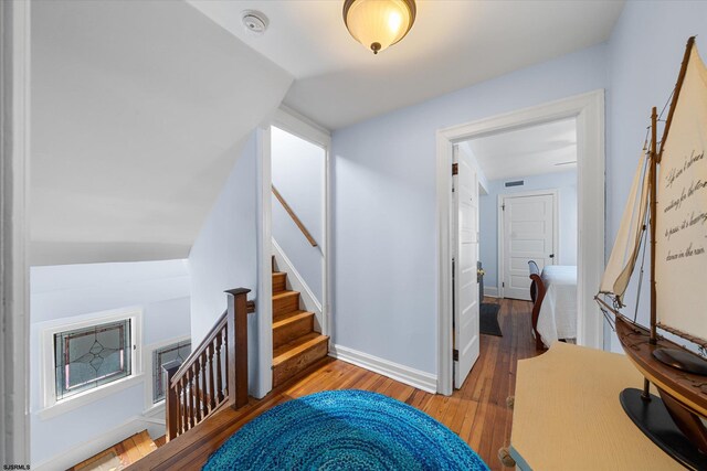 stairs with lofted ceiling and hardwood / wood-style flooring