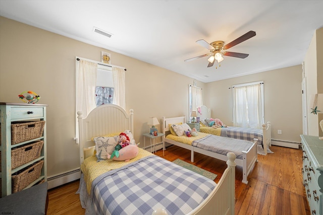 bedroom featuring ceiling fan, wood-type flooring, and baseboard heating