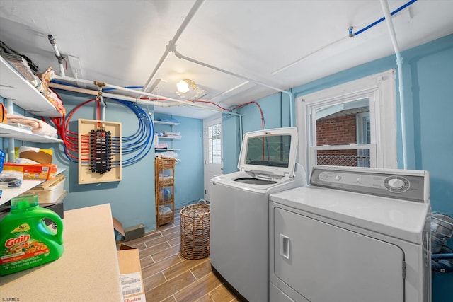 laundry room with wood-type flooring and separate washer and dryer