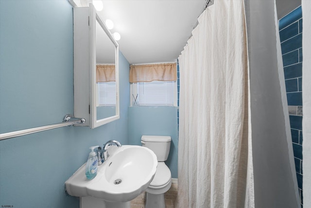 bathroom with curtained shower, sink, tile patterned flooring, and toilet