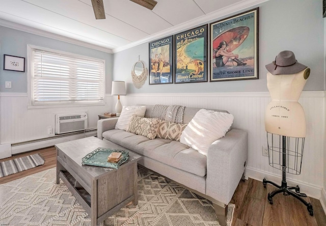 living room featuring hardwood / wood-style flooring, ornamental molding, a wall mounted AC, and a baseboard heating unit