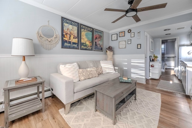 living room with ceiling fan, light wood-type flooring, and ornamental molding