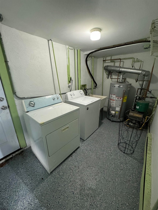 clothes washing area featuring gas water heater and washing machine and dryer