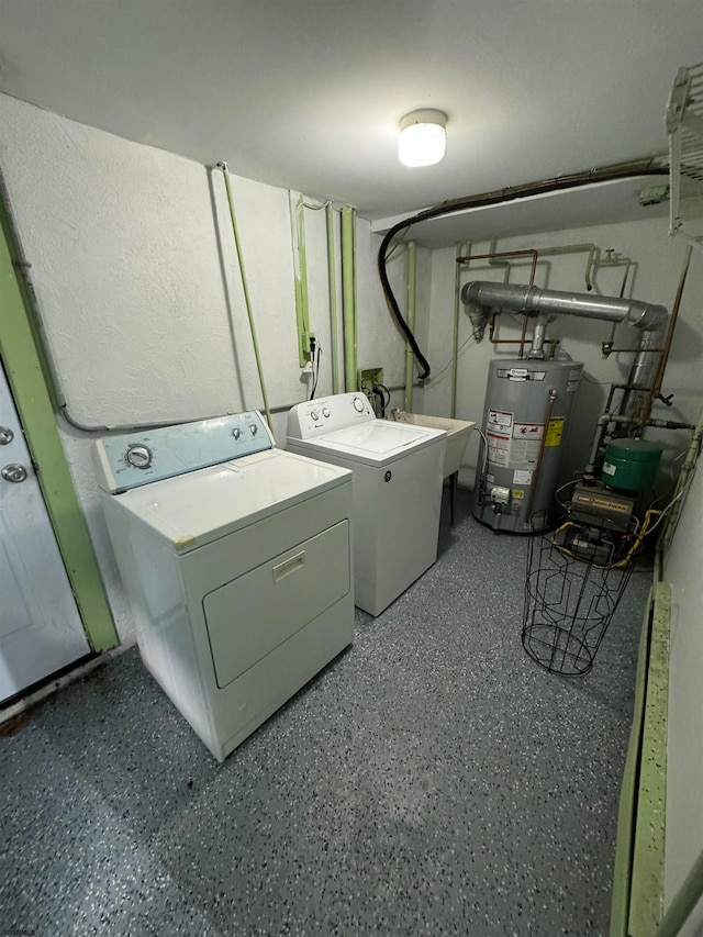 clothes washing area featuring washing machine and clothes dryer and gas water heater