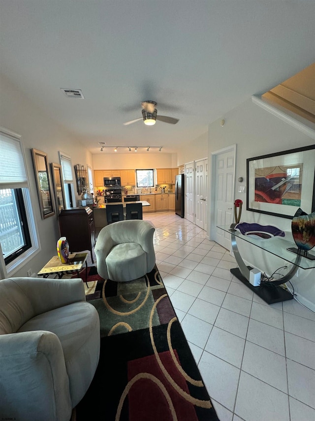 tiled living room with ceiling fan and a healthy amount of sunlight