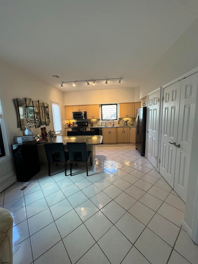 kitchen with a wealth of natural light, light brown cabinetry, sink, and appliances with stainless steel finishes