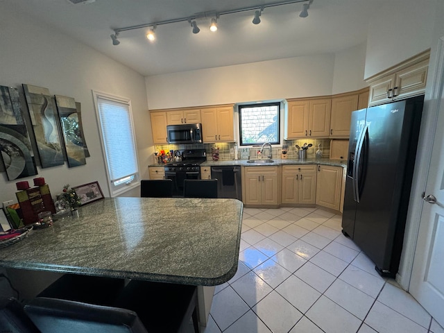 kitchen with backsplash, black appliances, sink, light brown cabinetry, and light tile patterned flooring