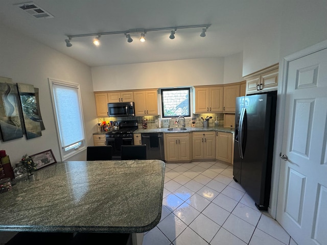 kitchen featuring sink, light brown cabinetry, backsplash, and black appliances