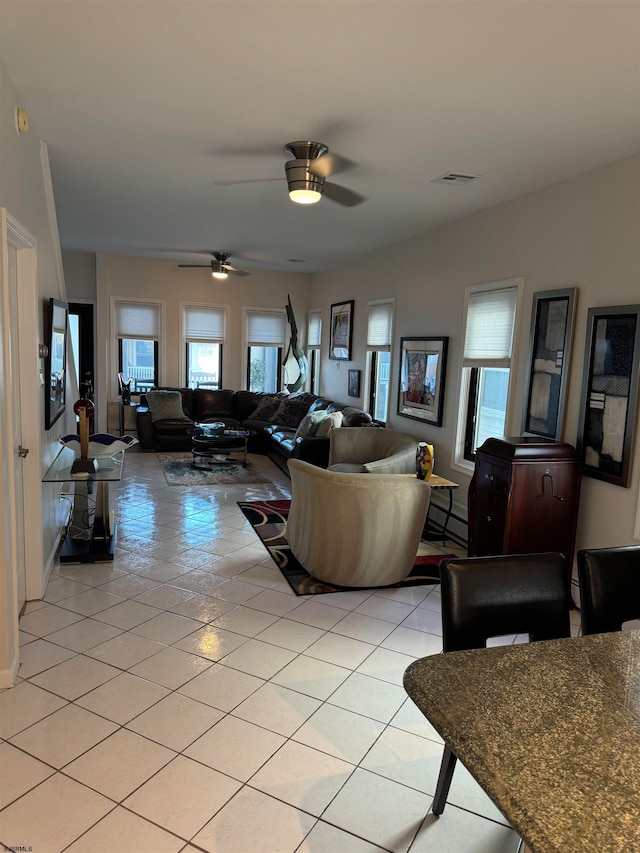 living room with ceiling fan, light tile patterned flooring, and baseboard heating