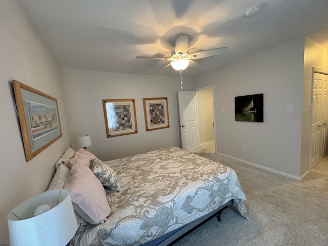 bedroom with ceiling fan, light colored carpet, and a closet