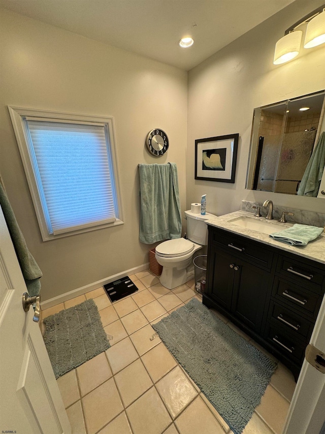 bathroom featuring a tile shower, tile patterned flooring, vanity, and toilet