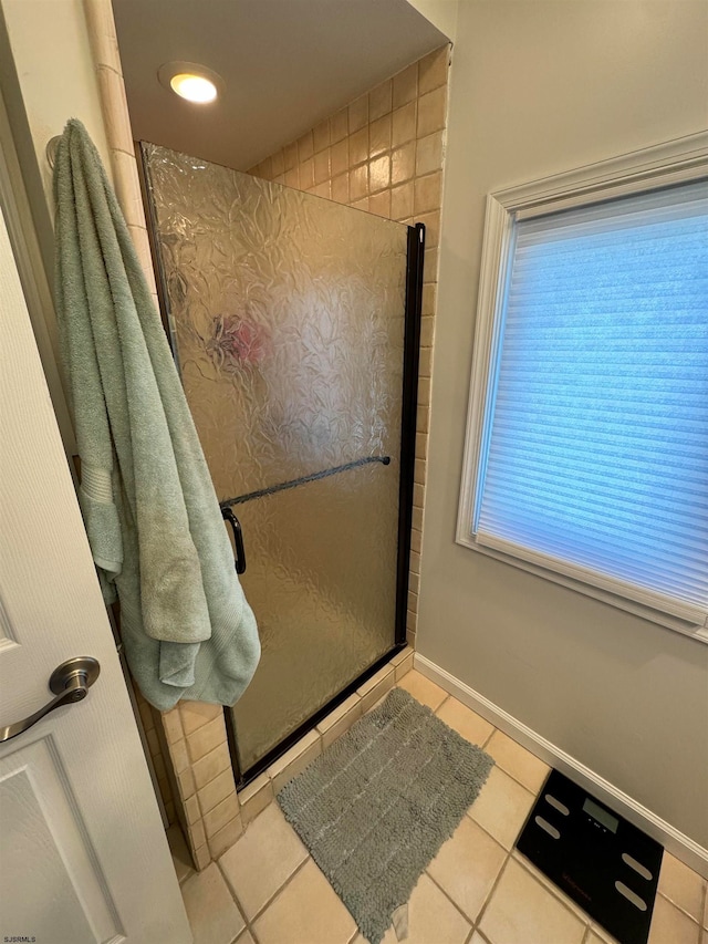 bathroom with tile patterned flooring and tiled shower