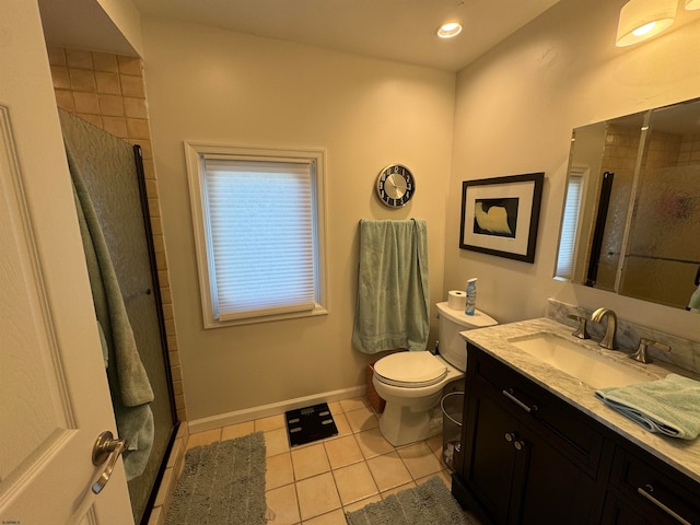 bathroom featuring tile patterned flooring, vanity, toilet, and a shower with door