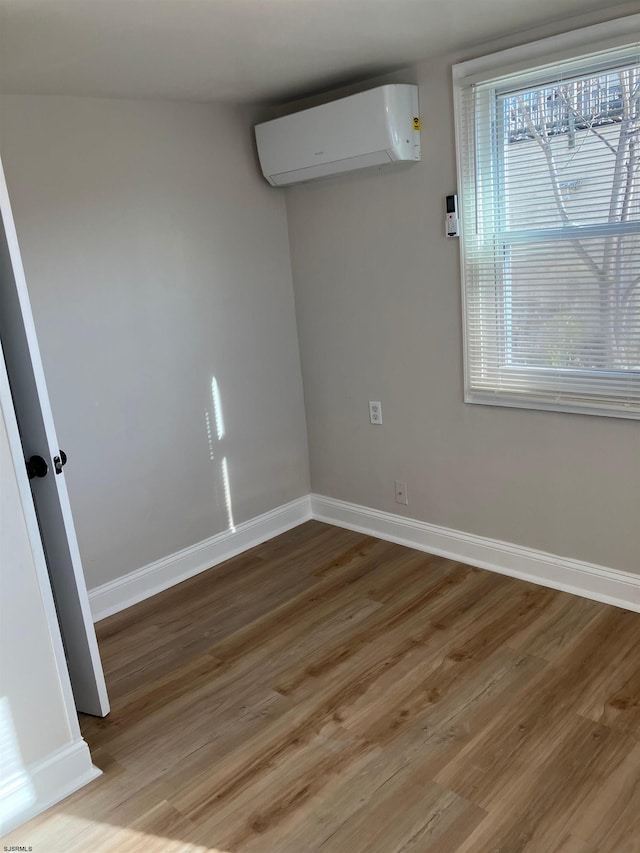 spare room featuring hardwood / wood-style floors and a wall mounted AC