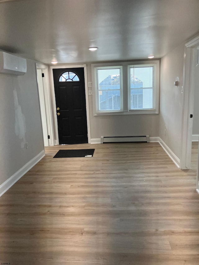 entrance foyer featuring light hardwood / wood-style flooring, an AC wall unit, and baseboard heating