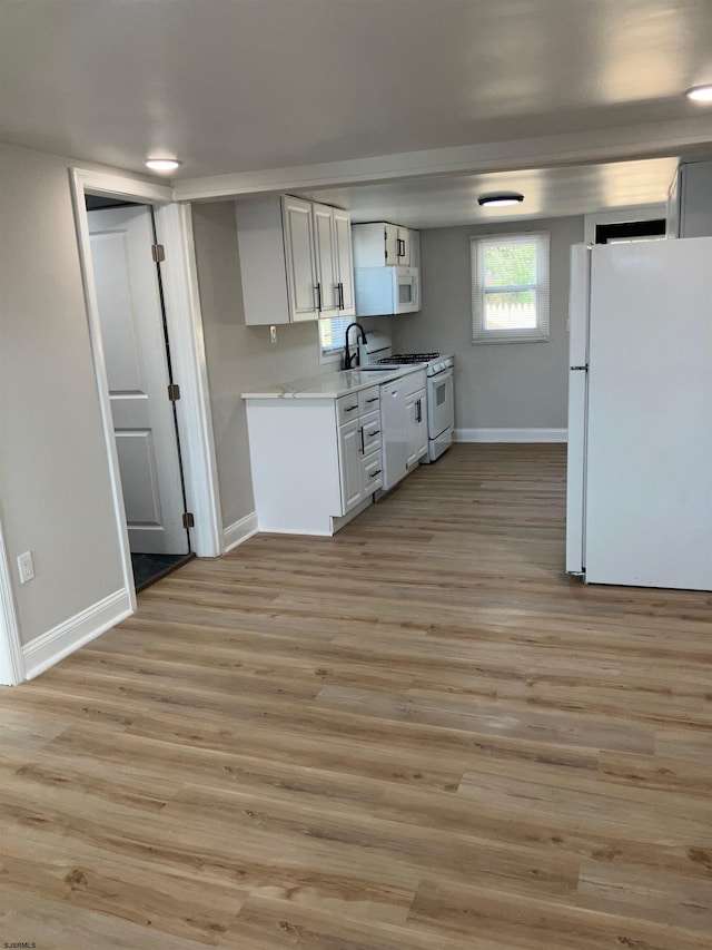 kitchen featuring white cabinets, white appliances, and light wood-type flooring