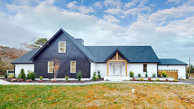 modern inspired farmhouse featuring a front yard and a garage