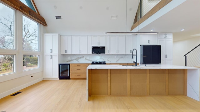 kitchen featuring sink, tasteful backsplash, refrigerator, beverage cooler, and white cabinets