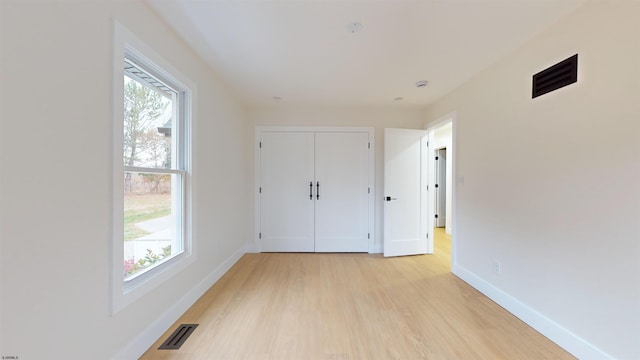 unfurnished bedroom featuring light hardwood / wood-style floors and a closet